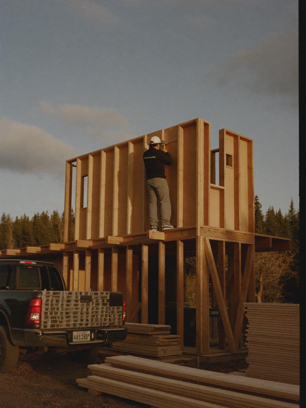 Framer working on the second floor of a custom home under construction at golden hour