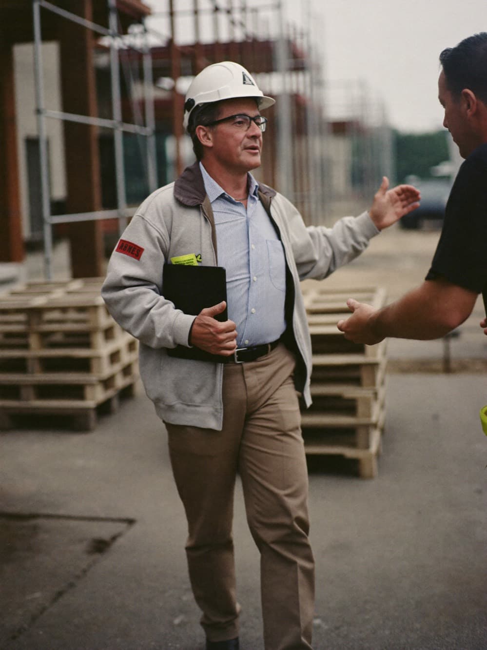 General contractor superintendent walking an active construction site with a tablet