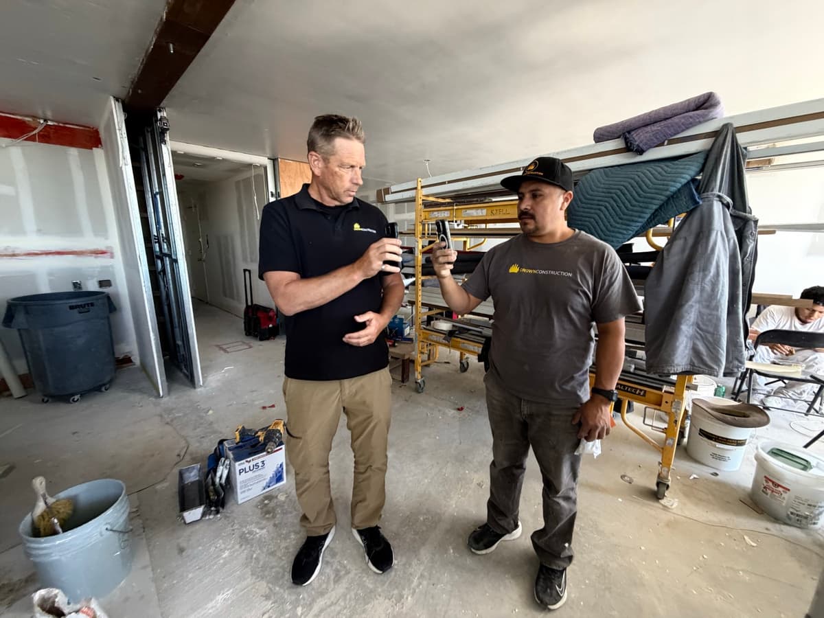 Crown Construction crew reviewing and signing the weekly Cal/OSHA safety topic on their phones at the jobsite